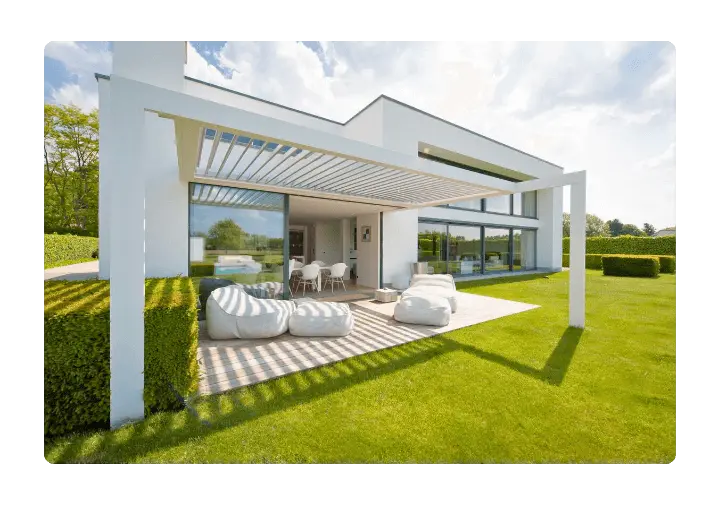 Modern white house with a stylish outdoor space and a louvered pergola over a wooden deck.