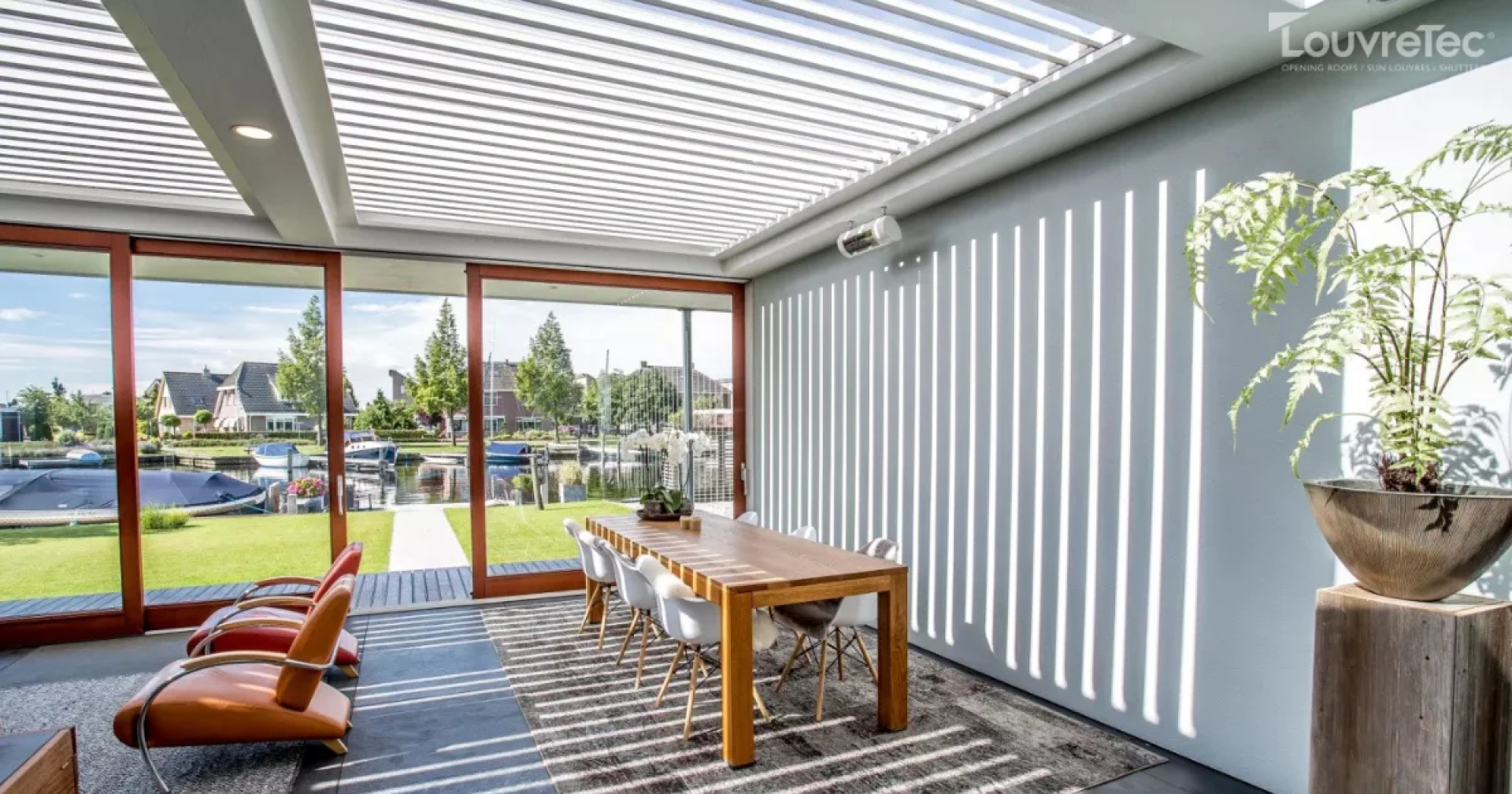 Modern outdoor area with a Louvretec motorized roof, offering flexible living by the sea.